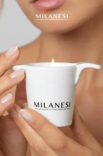Mani che tengono una candela da massaggio, campagna Milanesi, cosmetica naturale